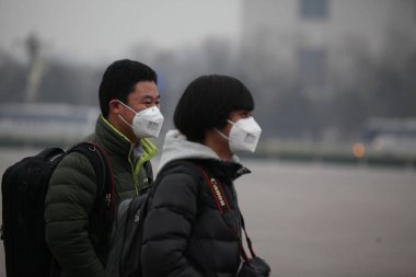 Reporters wearing face masks wait in heavy smog outside the Great Hall of the People during the Opening Session for the Second Session of the 12th National Committee of the CPPCC (Chinese Peoples Political Consultative Conference) in Beijing, China,  clipart