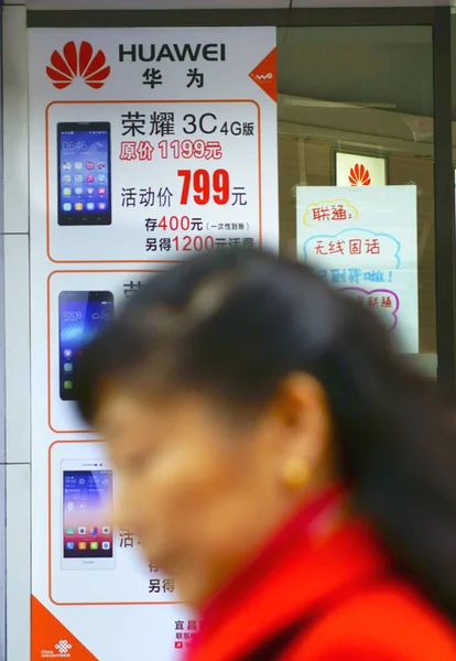 2014년 11월 20일 후베이성 이창시에서 화웨이 스마트폰 광고를 지나걷는 보행자 — 스톡 사진