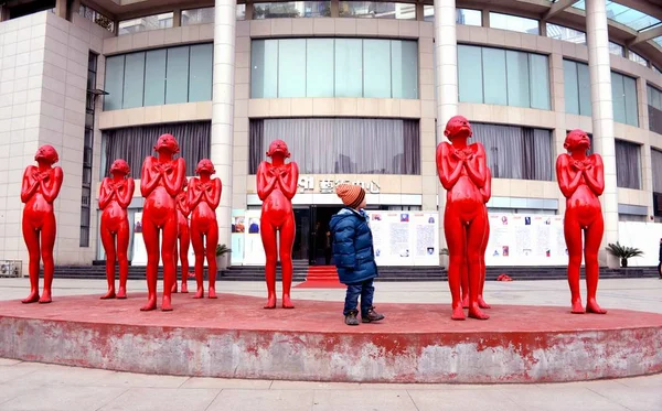 2013年1月13日 中国中部江西省南昌市一条街上的一个男孩在看雕塑 — 图库照片