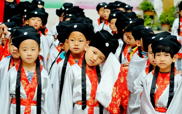 2014年9月10日 中国北西部甘粛省蘭州市の教師の日に修小学校で行われた除幕式で 中国の古代学生の衣装を着た若い生徒たちが孔子像の前に列をなしていた — ストック写真