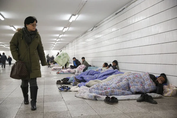 2014年12月26日 北京で給料をもらえなかった後 地下鉄朝陽門駅の地下通路に集まる出稼ぎ労働者を通り過ぎる乗客 — ストック写真