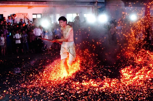 地元の中国人男性は 2013年7月20日 中国浙江省東部 パナナン郡のファンシャン村で行われた伝統的な火災ウォーキングの儀式中に 燃えている琥珀を裸足で走ります — ストック写真