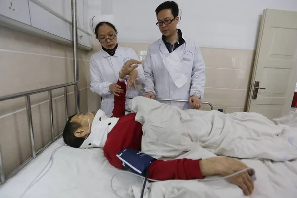 Kinesiska Läkare Och Sjuksköterska Undersöka Man Skadades Storm Vid Ett — Stockfoto