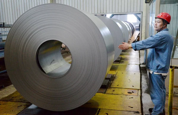 2014年8月13日 中国北部の河北省半安市にある河北鉄鋼グループの製鉄所で 生産ラインを通過するコイル鋼板のロールを中国人労働者が見守っている — ストック写真