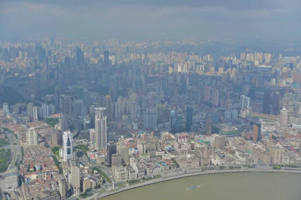 This picture taken from high in the Shanghai Tower under construction in Pudong shows a view of Huangpu River and Puxi with high-rise buildings and residential buildings in Shanghai, China, 30 August 2014.