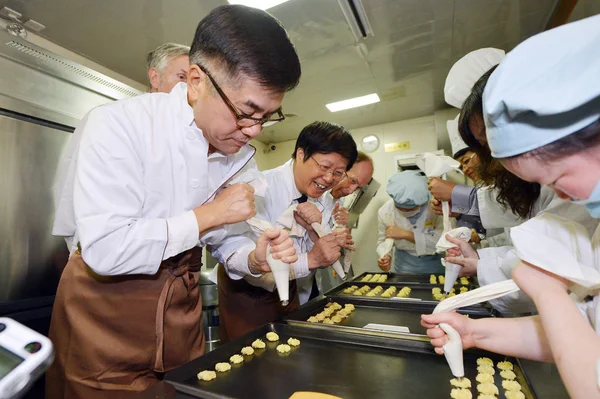 中国ゲイリー ロックへの米国大使は左 側近のベーカリー 2013 東中国江蘇省南京で将来の仕事のための知的障害の人々 を訓練する慈善団体のワーク ショップで知的障害の人々 とクッキーを作る — ストック写真