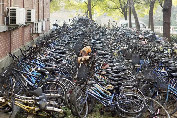 廃棄された自転車は 2014年12月22日 中国中部の湖南省長沙市にある中央南大学の寮の建物の前に駐車されています — ストック写真