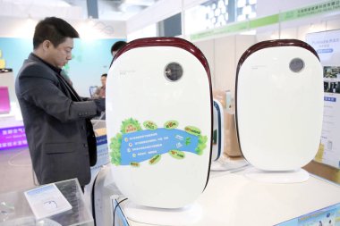A customer shops for air purifiers at a home appliance store in Shanghai, China, 12 November 2014 clipart