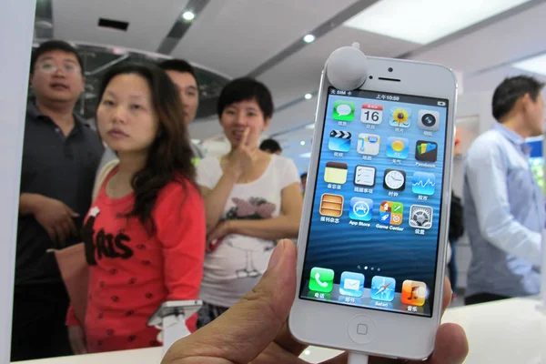 顧客は 海南省海河市の店でアップルのIphone 5スマートフォンを試してみる 2012年12月16日 — ストック写真