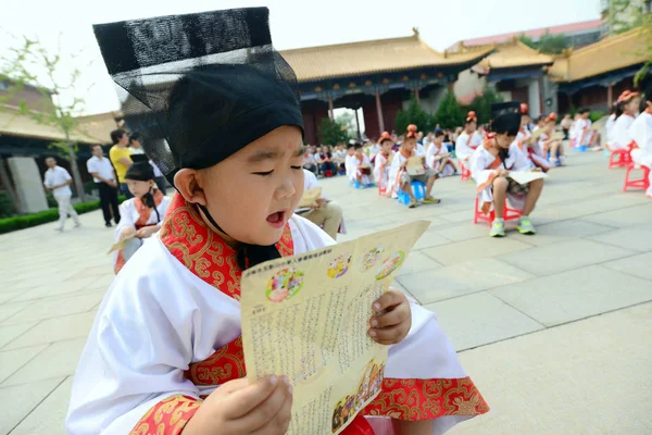2014年8月29日 中国東部山東省済南市で開校式を行った中国の男子学生が 伝統的な漢服を着た男子生徒を読み上げる — ストック写真
