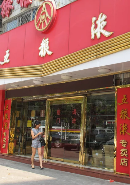 2014年10月13日 一位行人用手机走过海南省海口市五良叶的一家商店 — 图库照片