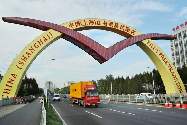 車両は 2013年9月27日に中国 パイロット自由貿易区の歓迎の看板の下を通過します — ストック写真