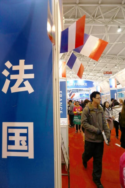 --FILE--Visitors walk past booths in the exhibition area for France during the 18th China International Education Exhibition Tour 2013 in Beijing, China, 9 March 2013