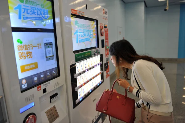 中国の顧客は 北京の地下鉄駅で Wechat アプリ内の自動販売機でボトル入り飲料を購入し 9月26日2013 — ストック写真