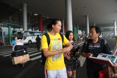 Female Chinese swimmer, Liu Zige, center, talks with a fan after she arrived back from the World Championship in Barcelona at the Beijing Capital International Airport in Beijing, China, 6 August 2013. clipart