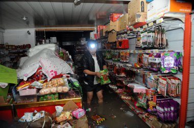 A man shops for food in a flooded supermarket after heavy rains caused by Typhoon Fitow in Yuyao city, east Chinas Zhejiang province, 9 October 2013 clipart