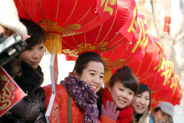 2012 日北東の中国黒竜江省ハルビン市にランタン フェスティバルを祝うために掛けている赤い提灯の下で若い中国の女性をもたらす — ストック写真