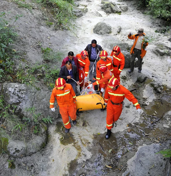 中国の救助隊は 2013年10月9日 中国中部湖南省張家江の天門山国有林公園でジャンプ中に事故で死亡した後 ハンガリーのウィングスーツのチラシヴィクトル コヴァッツのロープと道具を谷に運ぶ — ストック写真