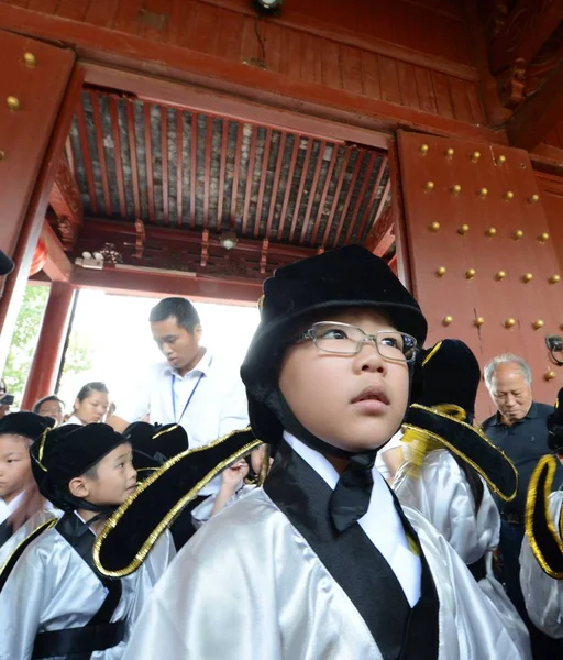 伝統的な中国の制服を着た1年生の生徒は Fuzimiao での新しい学期の最初の筆記式に出席するか または南京にある孔子廟 東中国江蘇省 9月1日2013 — ストック写真