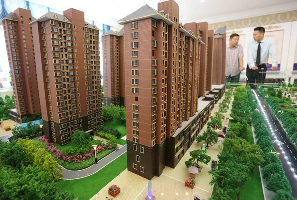 2013年9月7日 在中国中部河南省许昌市举行的房地产交易会上 一名中国员工向购房者介绍住宅公寓楼 — 图库照片