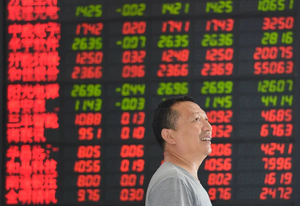 2013年9月23日 中国东部安徽省阜阳市一家股票经纪公司的股价 价格上涨为红色 价格下跌为绿色 一位中国投资者面带微笑 — 图库照片