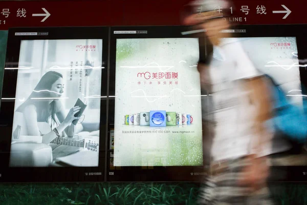 2013年5月18日 北京のマジックホールディングス インターナショナル社のMgフェイシャルマスクの広告を通り過ぎる歩行者 — ストック写真