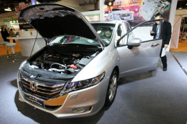 A visitor tries out a Honda Odyssey during an auto show in Shanghai, China, 27 December 2013 clipart