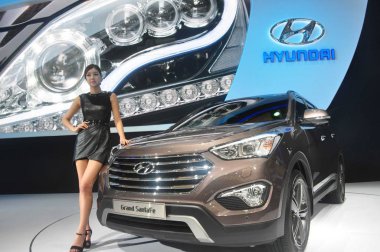 --FILE--A model poses with a Hyundai Grand SantaFe car during the 15th Shanghai International Automobile Industry Exhibition in Shanghai, China, 29 April 2013. clipart