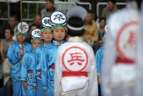 異なるチェスの駒として別の衣装を着て小学生 チーム杭州 東のあごの第 回中国国際チェス文化展中の試合で中国チェスをプレイする巨大な中国のチェス盤の上に立つ — ストック写真