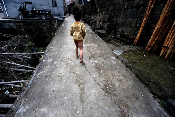 2013年11月27日 在中国东部浙江省温州市古莱镇 这个11岁的乞丐男孩 脑部严重受损 被祖母用铁链锁住 走在他家附近的一条小路上 — 图库照片