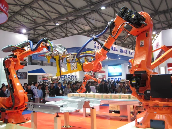 2013年11月5日 在中国上海举行的第十五届中国国际工业博览会上 参观者看到展示自动化工作的机器人 — 图库照片
