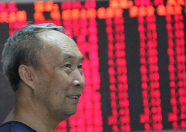 Китайський Інвестор Посміхається Він Дивиться Ціни Акцій Червоний Зростання Цін — стокове фото