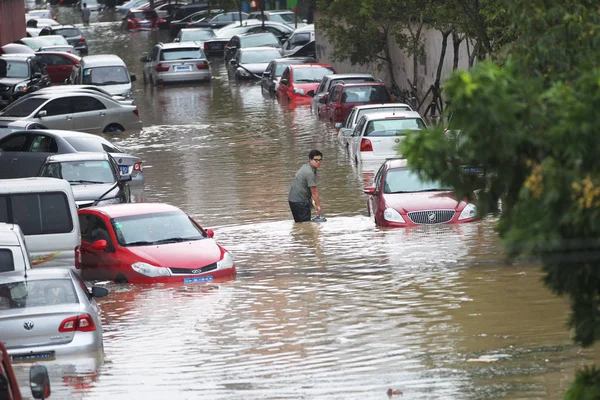 Китаец Проходит Мимо Частных Автомобилей Наполовину Затопленных Наводнениями После Сильных — стоковое фото