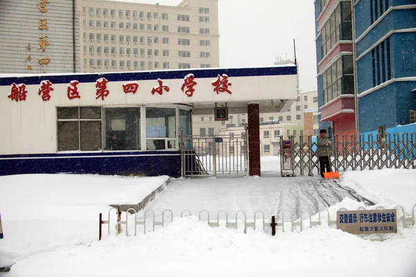 2013年11月18日 中国吉林省北東部吉林市の閉鎖された小学校の前で 作業員が雪を掃除する — ストック写真
