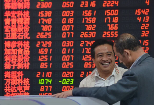 Китайський Інвестор Посміхається Він Розмовляє Іншим Перед Дисплеєм Показані Ціни — стокове фото