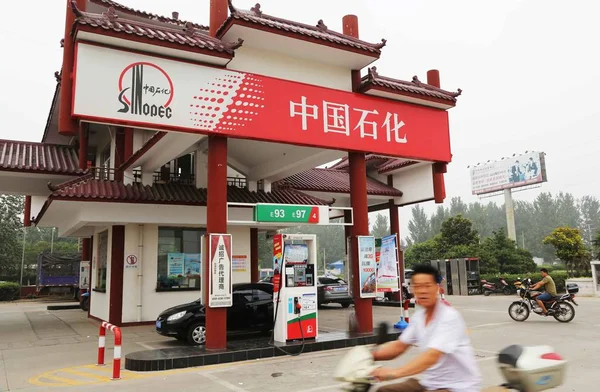2013年7月14日 在中国中部河南省许昌市 一名骑自行车的人骑着汽车在中石化加油站加油 — 图库照片