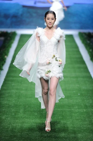 モデルは 2013 北京で中国ロンドンファッションウィークの春 2014年中 Tsaimeiyue ウェディング ドレスのファッションショーで新しい創造を表示します — ストック写真