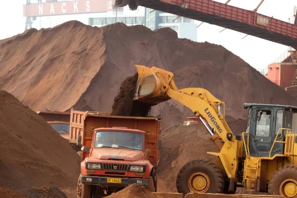 ブルドーザーは 2013年5月5日 中国東部江蘇省南通の港でトラックに鉄鉱石を降ろします — ストック写真