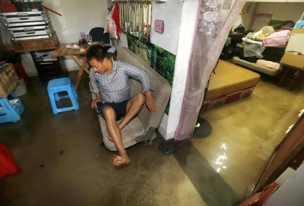 2013年10月7日 中国东部浙江省杭州市发生台风 带来的暴雨 一名中国男子坐在被洪水淹没的房子里的一张大瓦里 — 图库照片