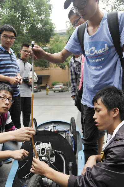中国人学生は 2013年10月8日 中国中部湖南省長沙市の湖南大学のキャンパスで 自家製の省エネレーシングカーに燃料を補給します — ストック写真