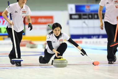 Yumie Funayama of Japan, center, releases a stone as her teammates Michiko Tomabechi, left, and Kaho Onodera prepare to sweep in the womens fifth round match against Australia during the Pacific-Asia Curling Championships 2013 in Shanghai, China, 14  clipart