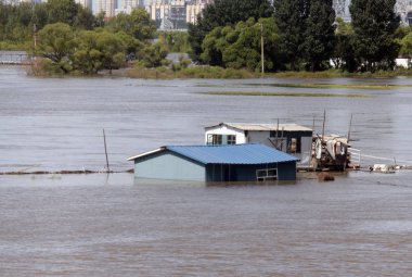 Houses are half-submerged by floodwaters in Songhua River in Harbin city, northeast Chinas Heilongjiang province, 26 August 2013 clipart