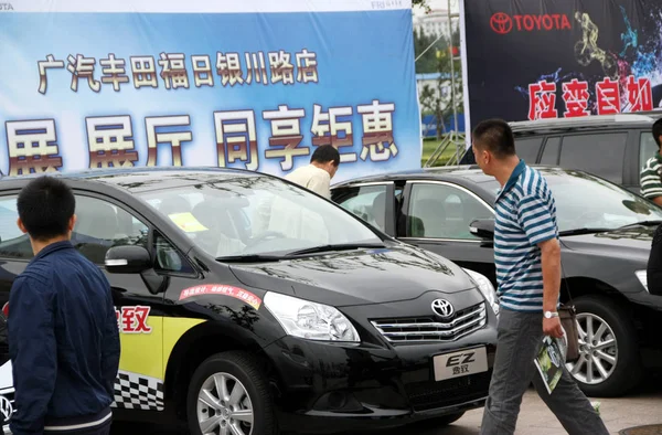 2011년 17일 산둥성 칭다오시에서 자동차 쇼에서 도요타 자동차를 바라보는 방문객들 — 스톡 사진