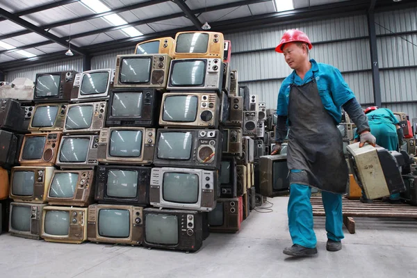 中国人労働者は 2013年5月30日 中国四川省南西部の新江市のリサイクル工場で 他の人の積み重ねを通り過ぎる時に分解される古いCrt 陰極線チューブ テレビセットを運ぶ — ストック写真