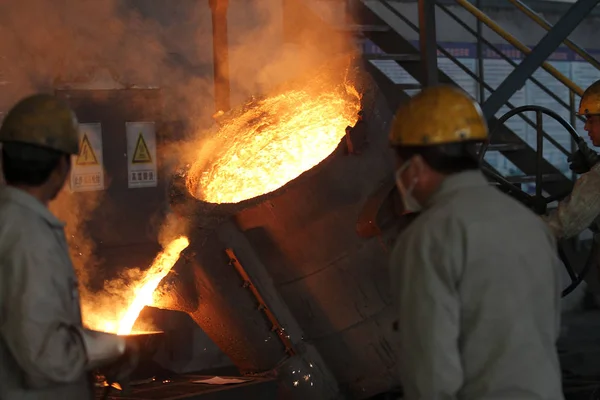 中国の労働者は 2013年11月13日 中国東部江蘇省南通市の鋳造所で溶鋼が金型に注がれているのを見る — ストック写真