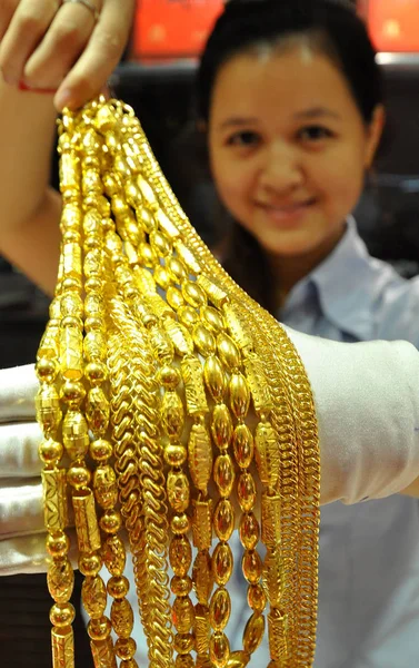 中国の店員が中国中部河北省半安の金店で金の装飾品を見せる 2013年10月8日 — ストック写真