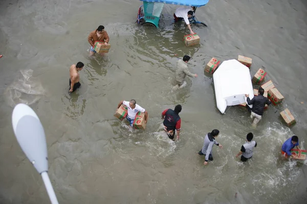 2013年10月9日 中国东部浙江省宁波市发生暴雨 当地市民在被洪水淹没的街道上运送救援物资 — 图库照片