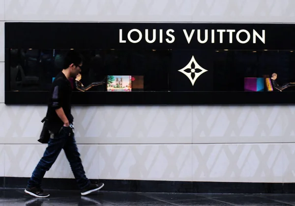 FILE--A pedestrian walks past a fashion boutique of Louis Vuitton