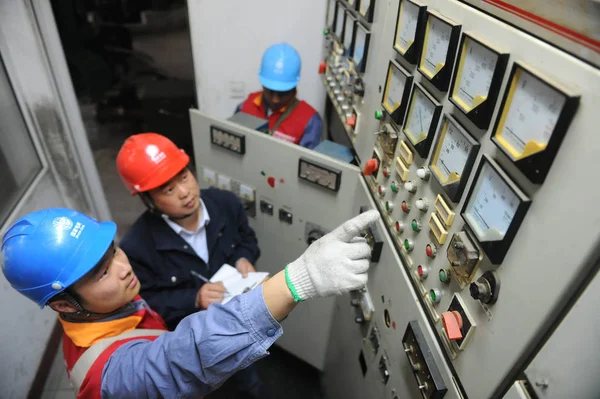 中国の労働者は 中国四川省南西部の中州の水力発電所で機械をチェックします 2013 — ストック写真