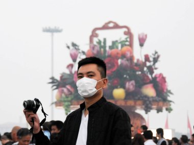 A masked tourist visits Tiananmen Square in heavy smog in Beijing, China, 28 September 2013 clipart